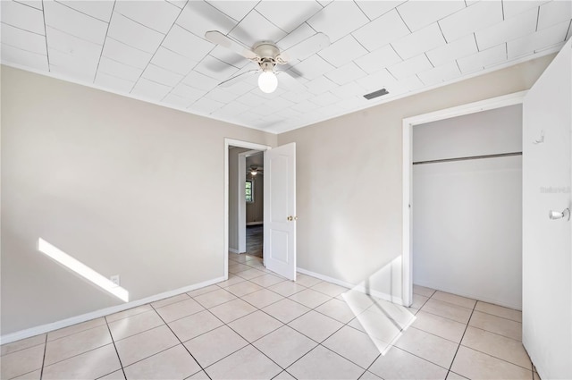 unfurnished bedroom with a closet, ceiling fan, and light tile patterned flooring