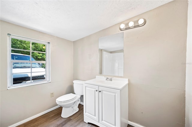 bathroom with vanity, toilet, hardwood / wood-style flooring, and a textured ceiling