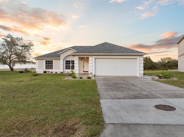 single story home featuring a lawn and a garage