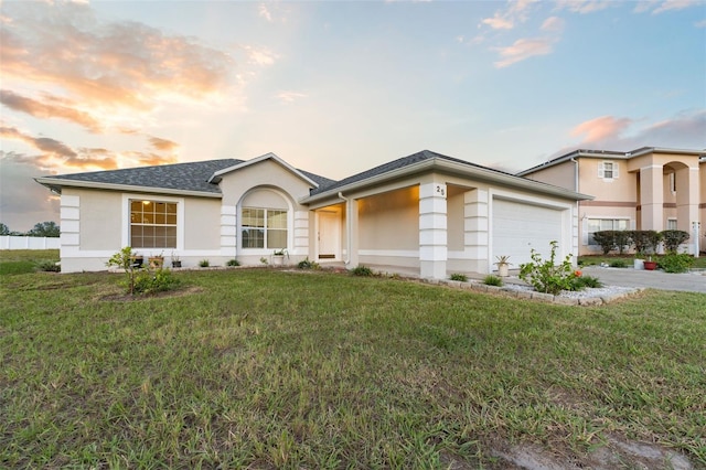 view of front of property with a garage and a yard