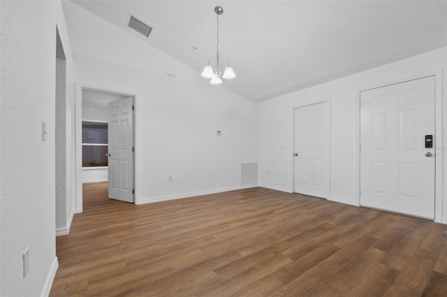 interior space featuring vaulted ceiling, a notable chandelier, and dark hardwood / wood-style floors