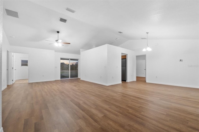 unfurnished living room with ceiling fan with notable chandelier, light hardwood / wood-style flooring, and lofted ceiling