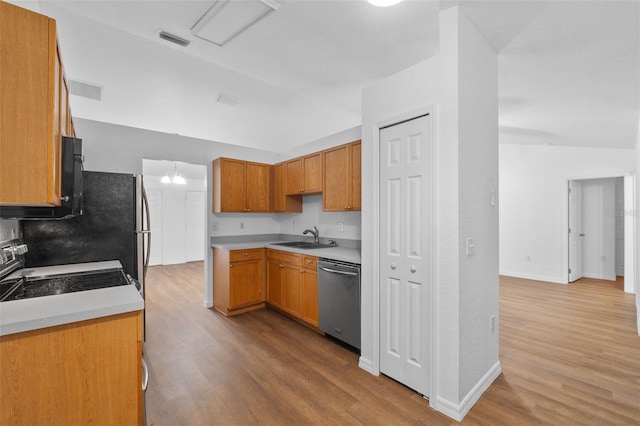 kitchen with range, sink, dishwasher, lofted ceiling, and light hardwood / wood-style flooring