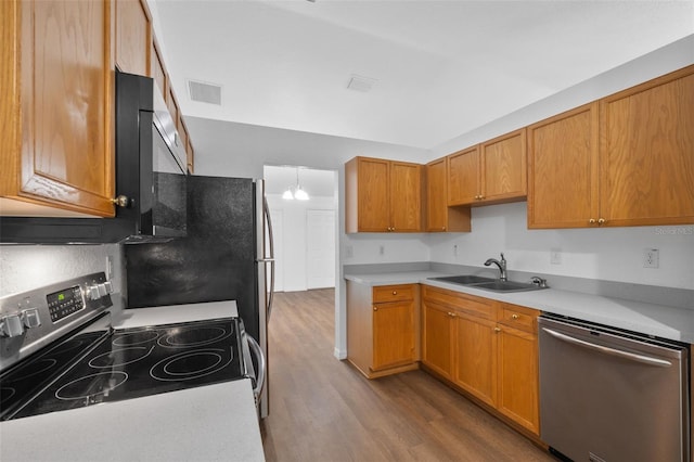 kitchen featuring hardwood / wood-style floors, a chandelier, sink, and appliances with stainless steel finishes