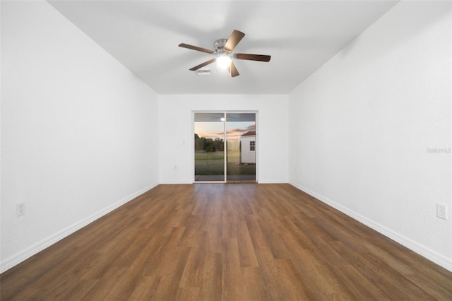 empty room with dark hardwood / wood-style floors and ceiling fan