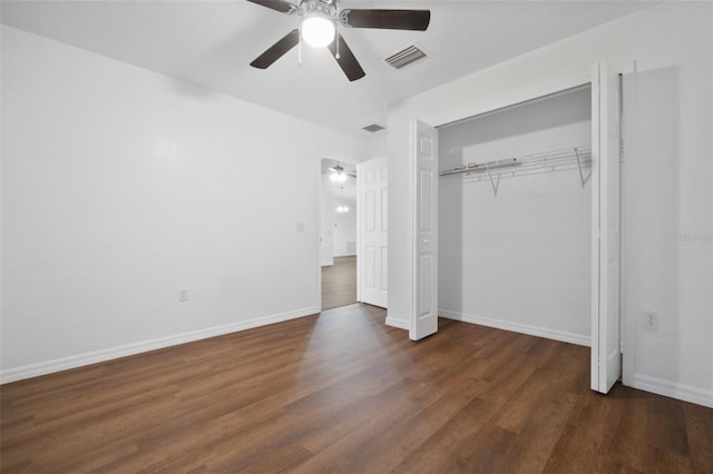 unfurnished bedroom featuring dark wood-type flooring, ceiling fan, and a closet