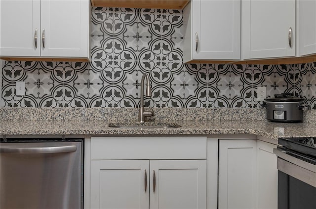 kitchen with tasteful backsplash, white cabinets, and sink