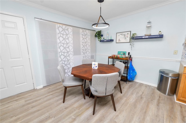 dining space featuring crown molding and light hardwood / wood-style flooring