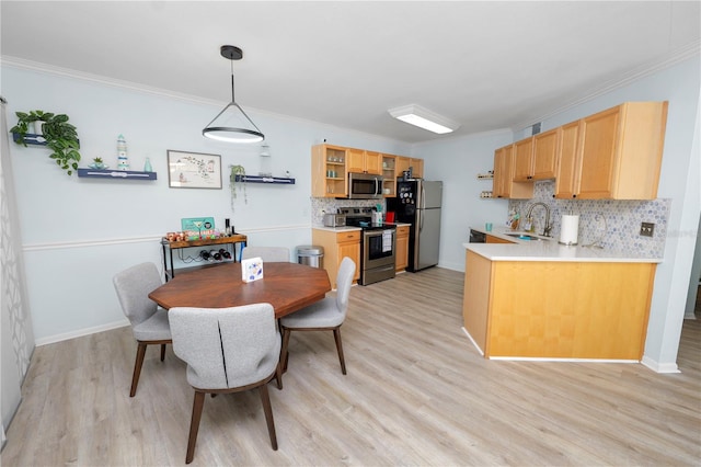 dining room with ornamental molding, light hardwood / wood-style floors, and sink