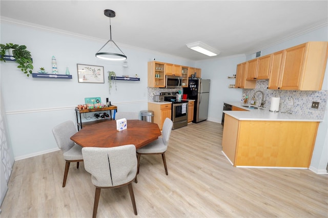 dining space featuring sink, crown molding, and light hardwood / wood-style floors