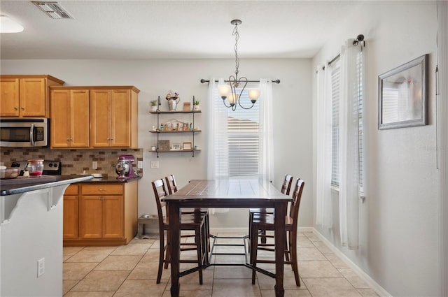 1849 Charleston Ln, Bartow, FL 33830 - kitchen featuring stainless steel appliances, a chandelier, light tile patterned floors, backsplash, and dark countertops