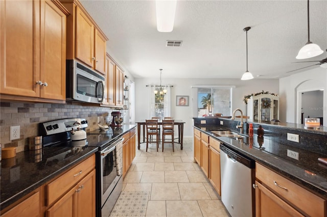 1849 Charleston Ln, Bartow, FL 33830 - kitchen with appliances with stainless steel finishes, a sink, tasteful backsplash, pendant lighting, and a textured ceiling