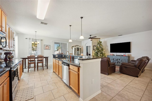 1849 Charleston Ln, Bartow, FL 33830 - kitchen featuring stainless steel appliances, dark countertops, a ceiling fan, a chandelier, and a sink