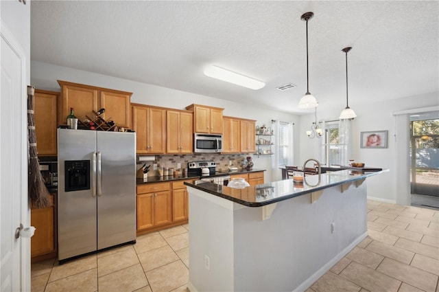 1849 Charleston Ln, Bartow, FL 33830 - kitchen featuring stainless steel appliances, light tile patterned floors, plenty of natural light, and a textured ceiling