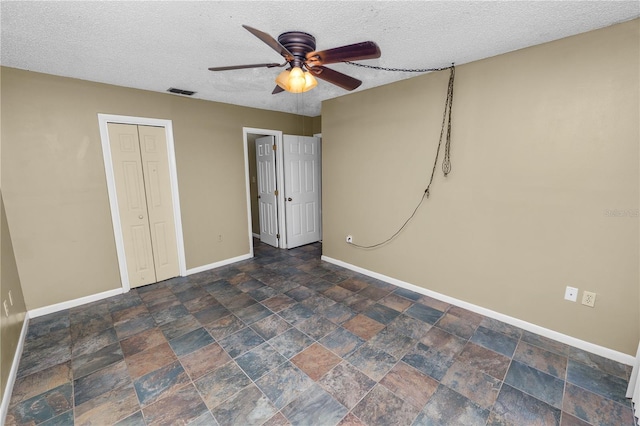 unfurnished bedroom featuring a textured ceiling, ceiling fan, and a closet