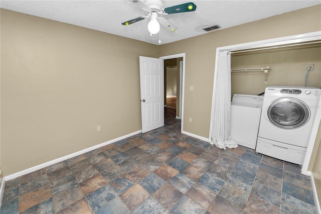 washroom featuring ceiling fan, separate washer and dryer, and a textured ceiling