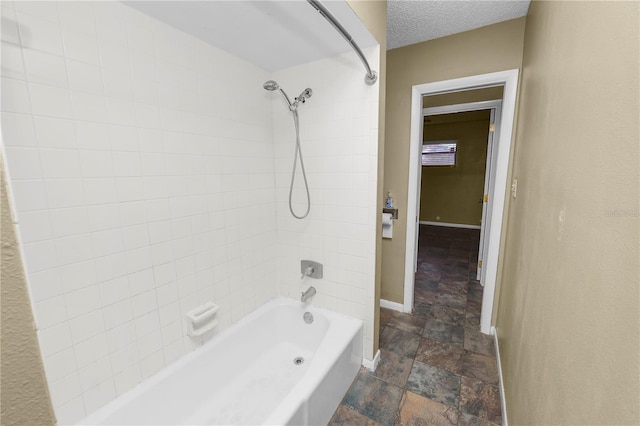 bathroom with tiled shower / bath and a textured ceiling