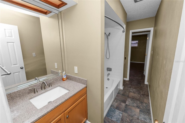 bathroom with bathing tub / shower combination, vanity, and a textured ceiling