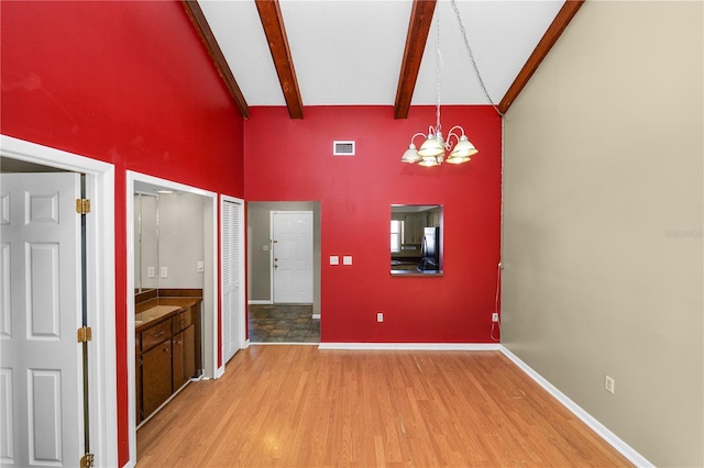 interior space with beamed ceiling, wood-type flooring, high vaulted ceiling, and a notable chandelier