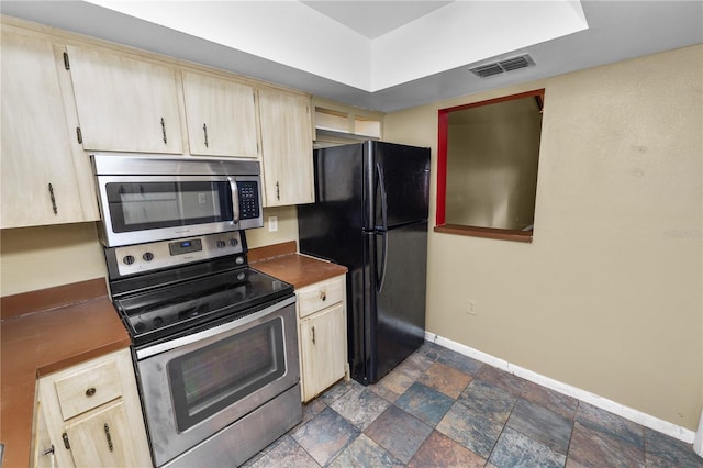 kitchen with light brown cabinetry and appliances with stainless steel finishes