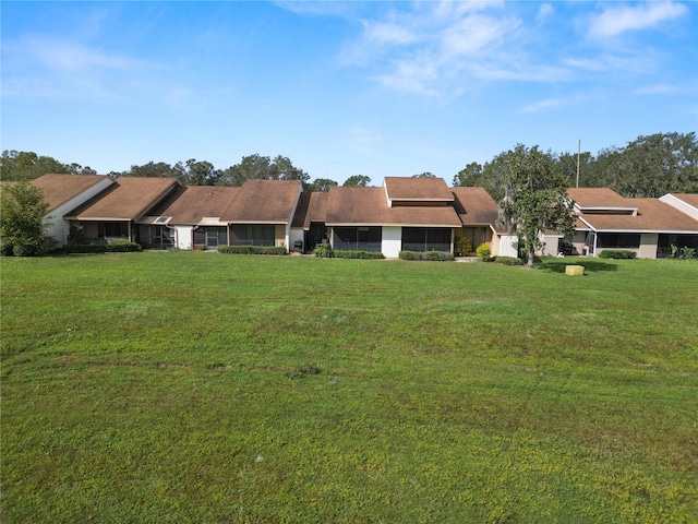 rear view of property featuring a lawn