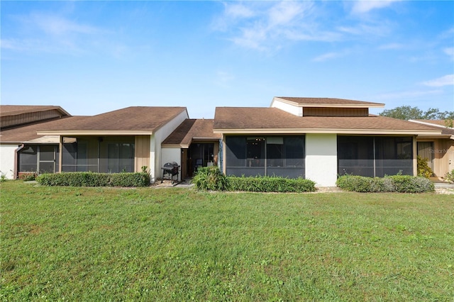 ranch-style home featuring a sunroom and a front yard