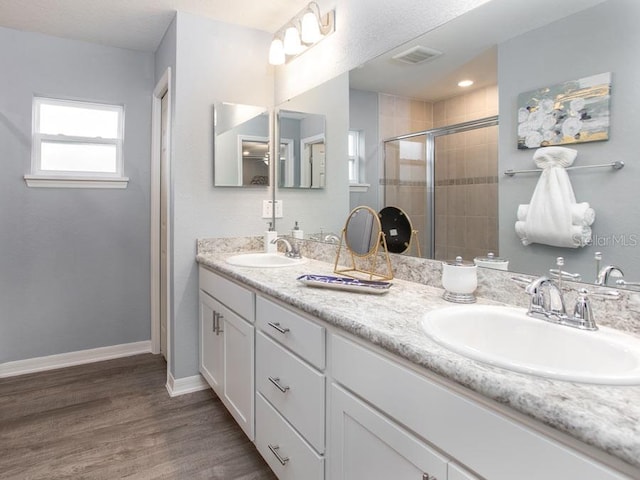 bathroom featuring walk in shower, hardwood / wood-style floors, and vanity