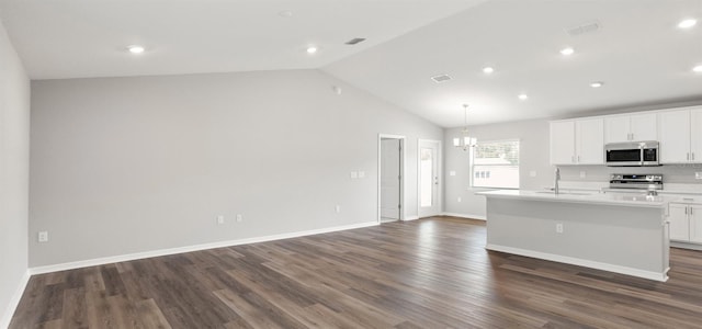 572 SW 77th Cir, Ocala, FL 34480 - kitchen featuring appliances with stainless steel finishes, vaulted ceiling, an island with sink, dark wood-style flooring, and open floor plan