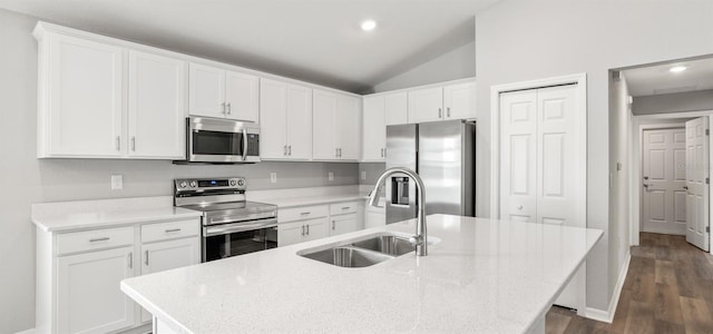 572 SW 77th Cir, Ocala, FL 34480 - kitchen with stainless steel appliances, a sink, a center island with sink, white cabinetry, and vaulted ceiling