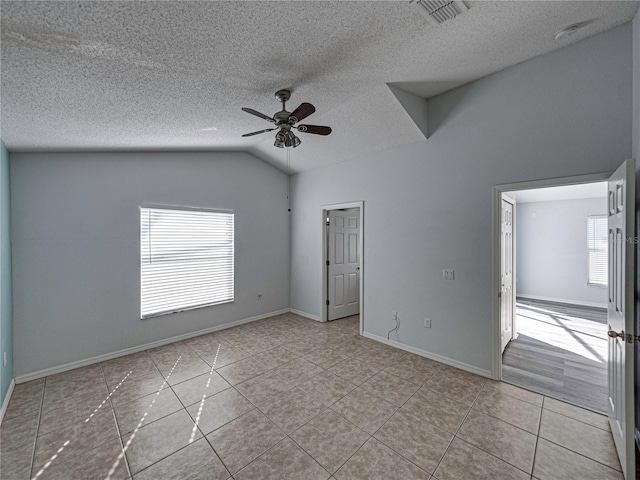 unfurnished room featuring lofted ceiling, ceiling fan, and a textured ceiling