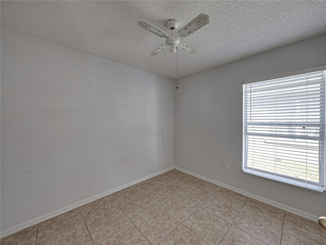 tiled empty room featuring ceiling fan and a textured ceiling