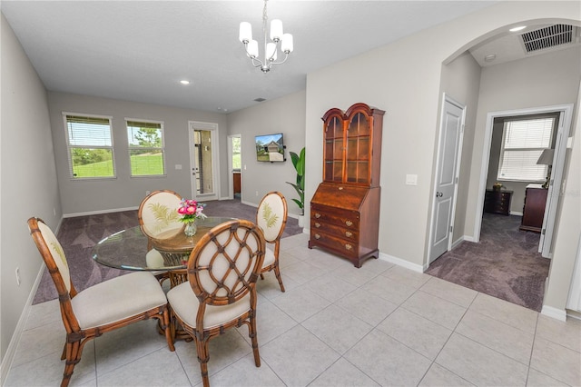 tiled dining room featuring a chandelier