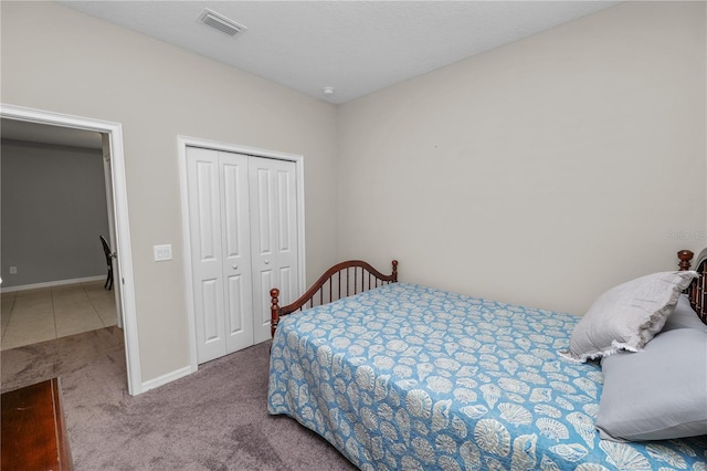 bedroom with light carpet and a closet