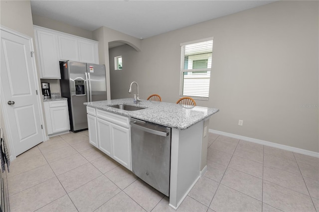 kitchen with white cabinets, appliances with stainless steel finishes, an island with sink, and sink