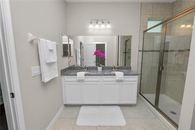 bathroom with tile patterned flooring, vanity, and a shower with door