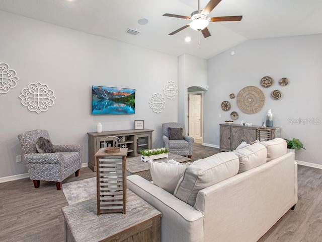 living room with vaulted ceiling, ceiling fan, and wood-type flooring