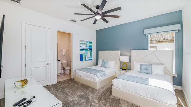 bedroom with ensuite bath, ceiling fan, and dark carpet