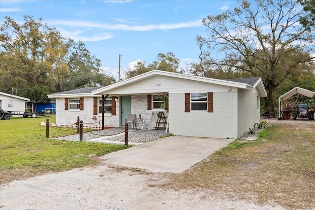 ranch-style home with a front yard, a porch, and a carport