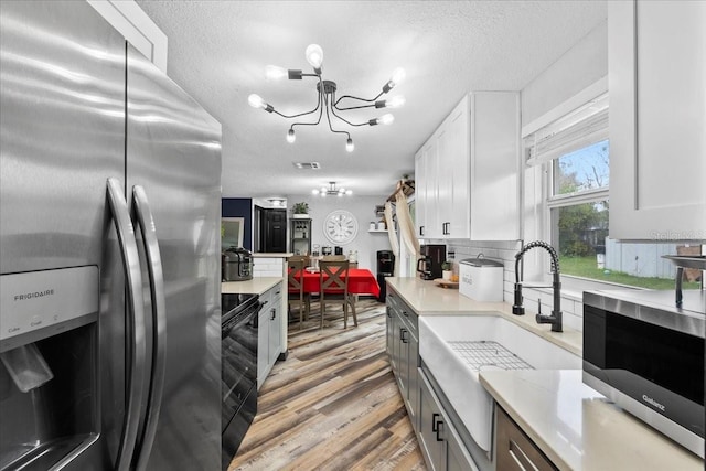 kitchen with decorative backsplash, white cabinets, appliances with stainless steel finishes, and sink