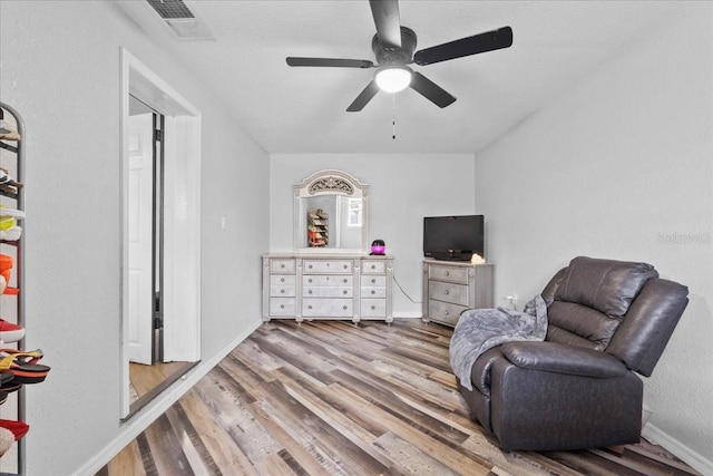 living area featuring ceiling fan and hardwood / wood-style flooring