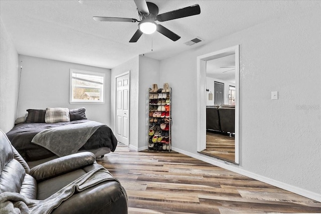 bedroom featuring ceiling fan, a closet, a textured ceiling, and light hardwood / wood-style flooring