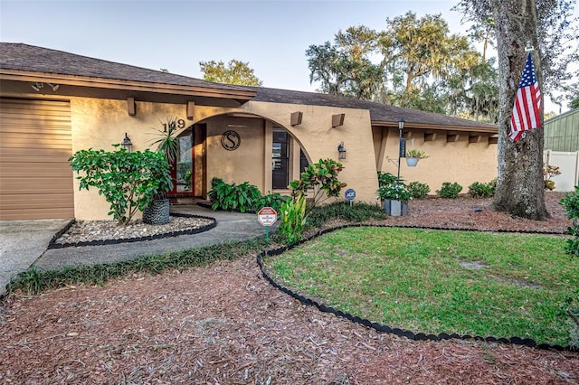 ranch-style home featuring a garage and a front lawn