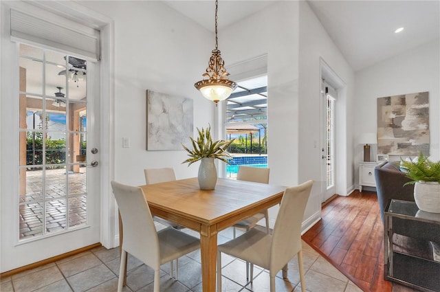 tiled dining area with ceiling fan and lofted ceiling