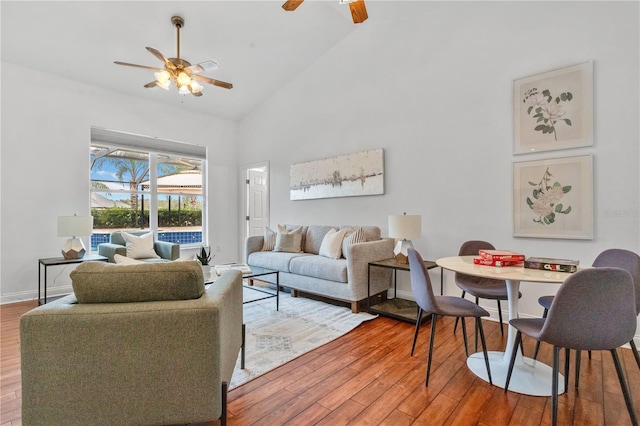 living room featuring ceiling fan, wood-type flooring, and high vaulted ceiling