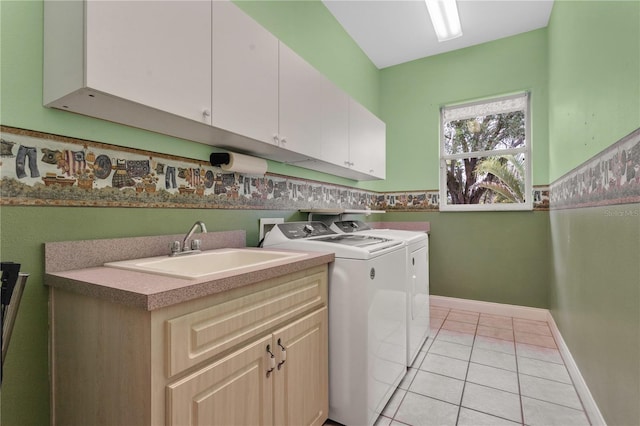 laundry room featuring light tile patterned flooring, cabinets, washer and dryer, and sink