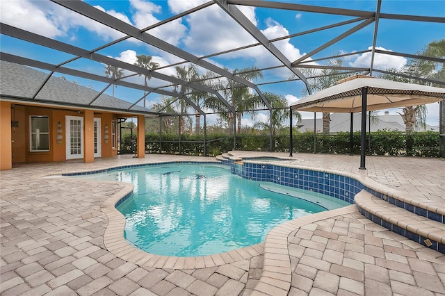 view of pool with a lanai, an in ground hot tub, and a patio