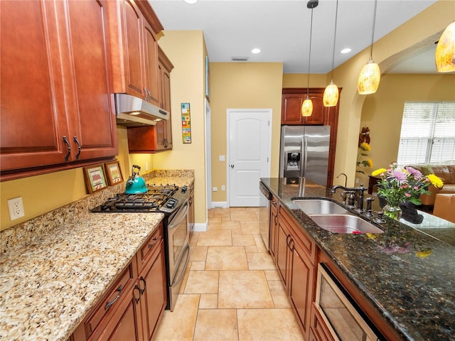 kitchen with pendant lighting, stainless steel appliances, sink, and light stone counters