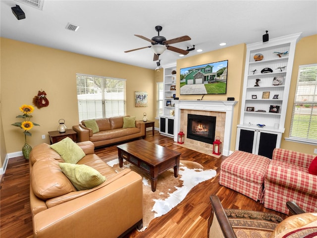 living room with wood-type flooring, a tile fireplace, ceiling fan, and plenty of natural light