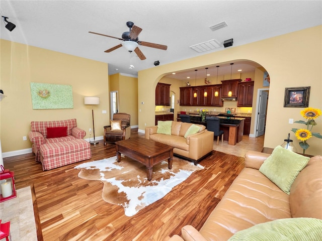 living room with ceiling fan and light hardwood / wood-style flooring