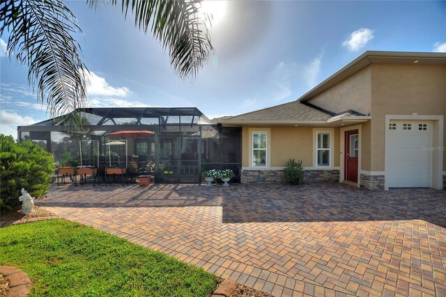 view of patio / terrace with a garage and a lanai